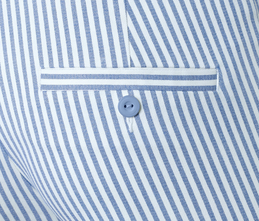 Detail einer gestreiften Stretchhose mit Knopf.