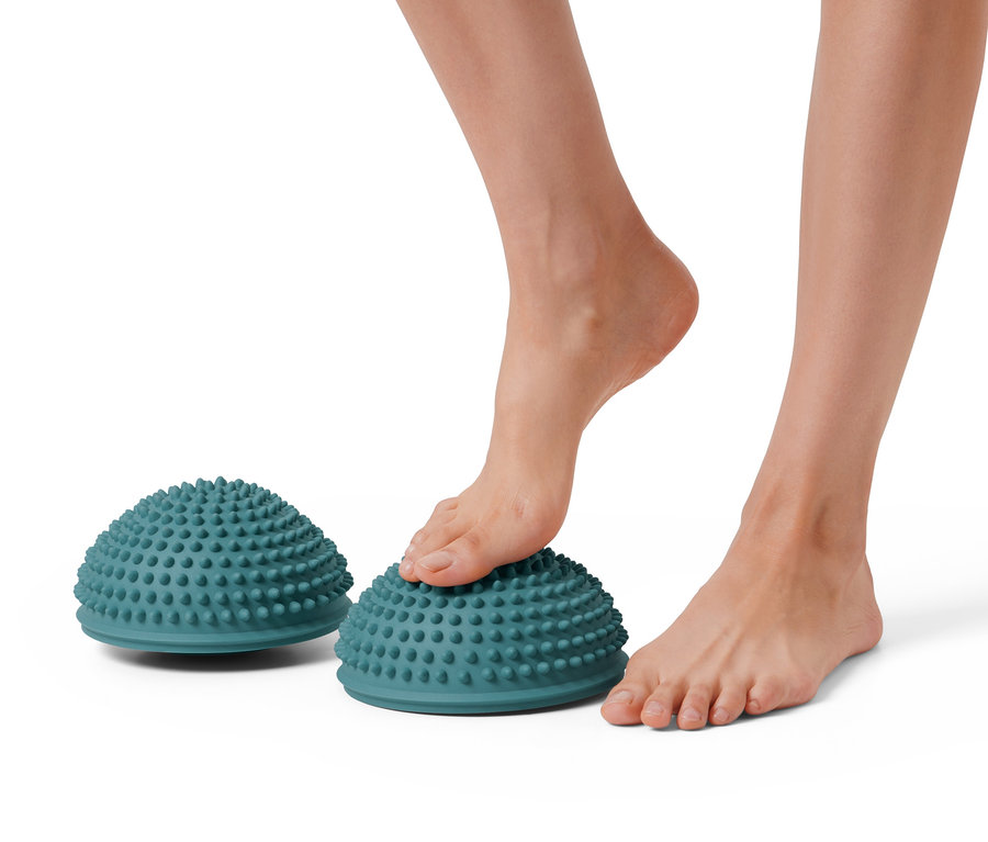 Ein Fuß steht auf einem von zwei Balance-und-Massage-Pads.