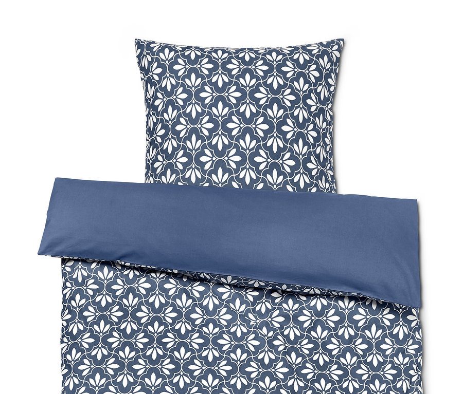 Blau-weiße Bettwäsche mit Blumenmuster und blauem Rand.