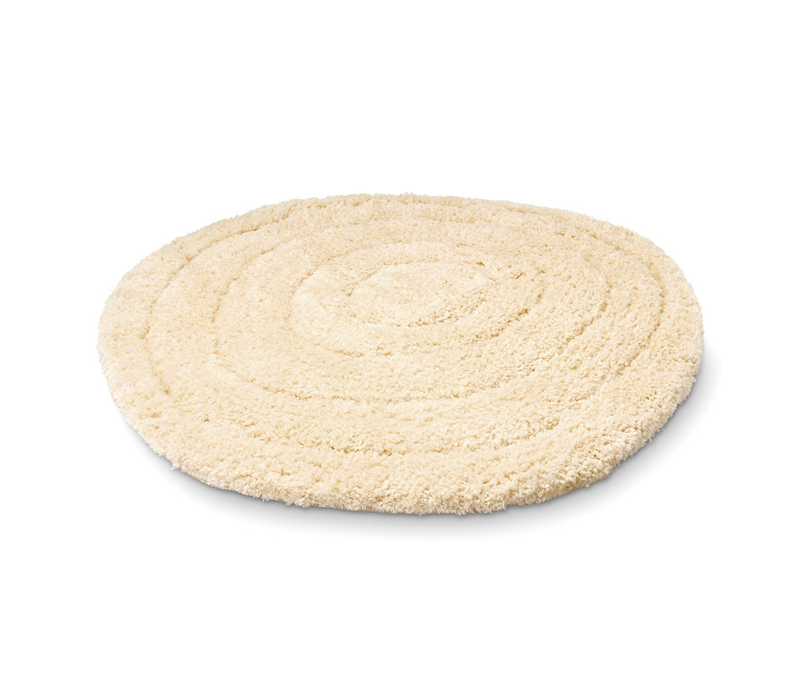 Eine beige Badematte in organischer Form.