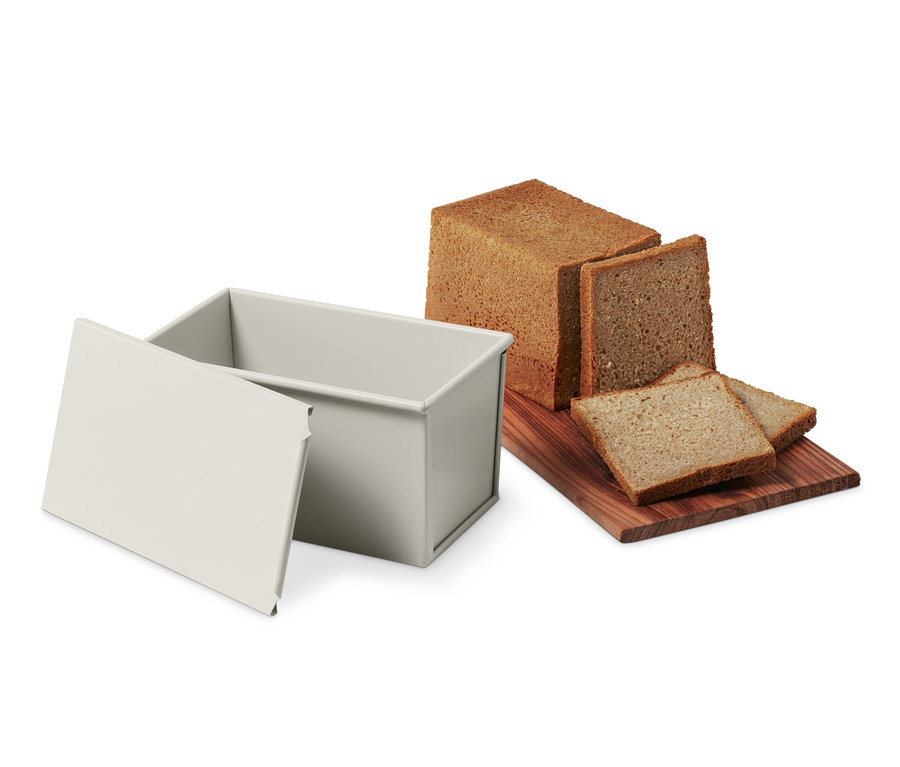 Vollkorn- und Toastbrot-Backform neben Brotlaib und Brotscheiben.