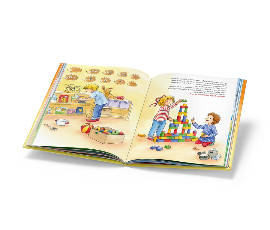 Illustration in einem Buch zeigt einen Jungen, der Spielzeug in ein Regal räumt, und zwei Mädchen, die einen Turm aus bunten Bauklötzen bauen. Das Buch "Mein großes Conni-Vorlesebuch" ist sichtbar.