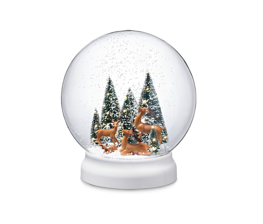 In der LED-Outdoor-Schneekugel stehen Hirschfiguren zwischen schneebedeckten Bäumen.
