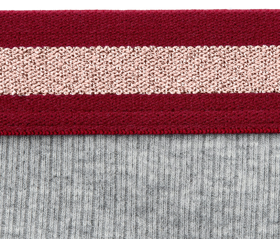 Detailaufnahme von grauen Rippen-Hipstern mit einem bordeauxroten und roségoldfarbenen Streifenbund.