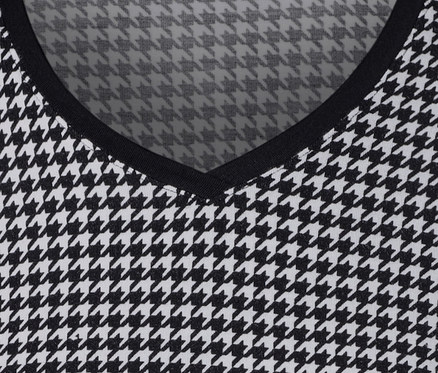 Detailansicht eines bedruckten Blusenshirts mit schwarz-weissem Hahnentrittmuster.