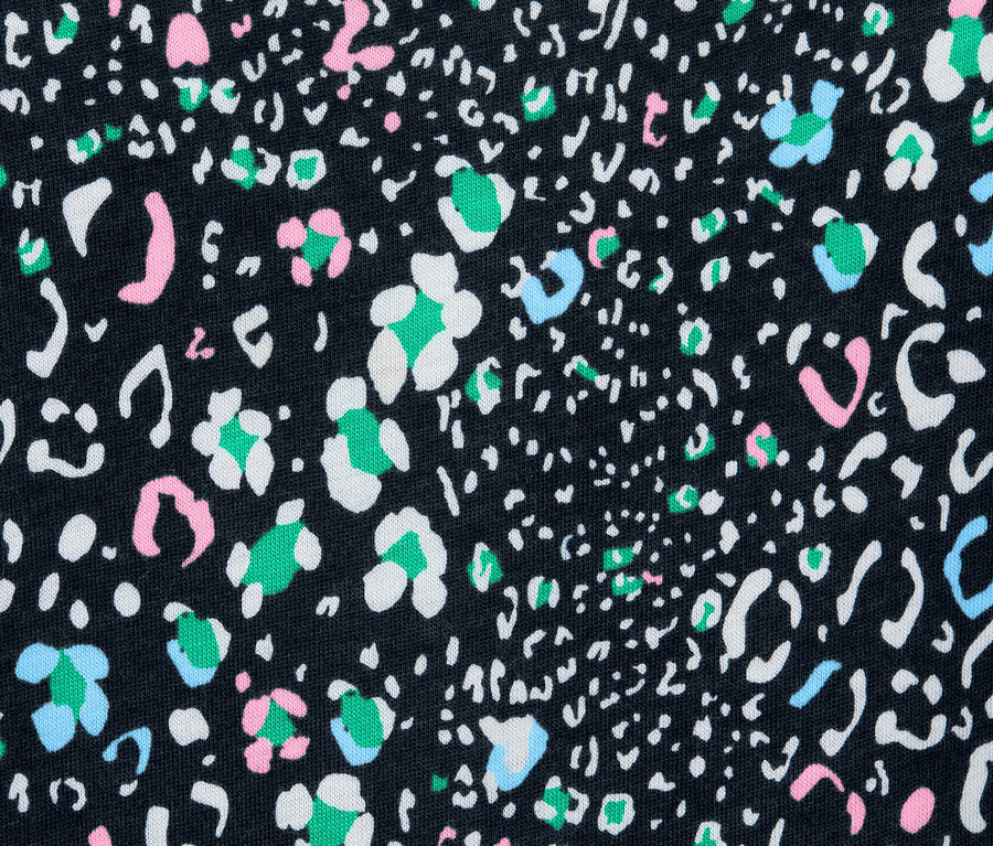 Detailaufnahme eines Langarmshirts mit schwarzem Hintergrund und einem Muster aus weißen, rosa-, grün- und blaufarbenen Flecken.