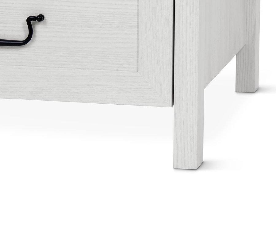 Detailansicht eines weißen Kleiderschranks mit Schublade und schwarzem Griff.