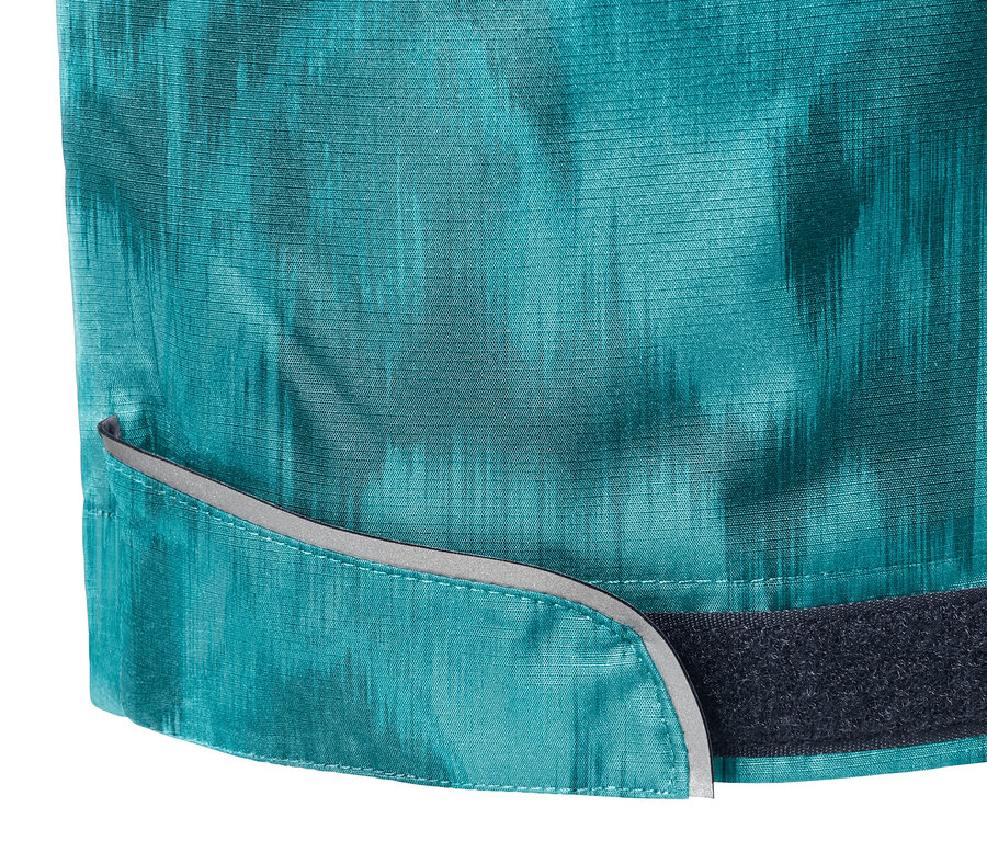 Detailaufnahme einer Regenhose mit Alloverprint, Reflektoren und Klettverschluss.