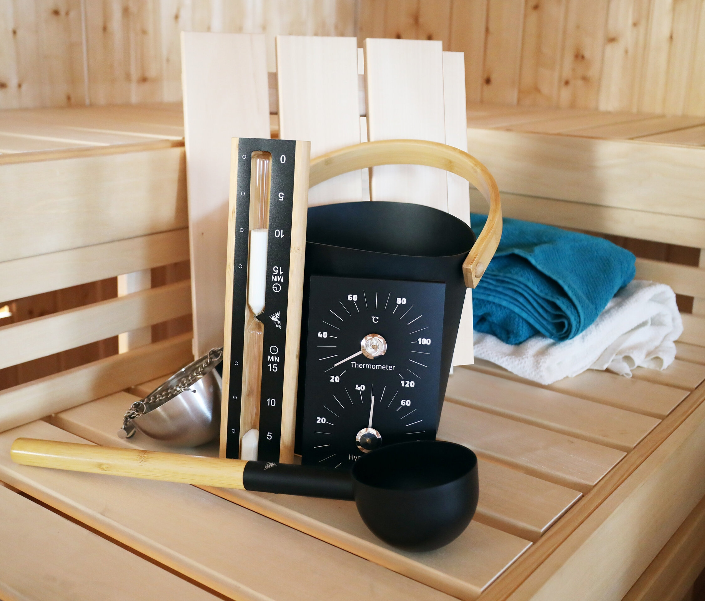 Karibu Sauna-Zubehör-Set »Premium« auf einer Holzbank in einer Sauna.
