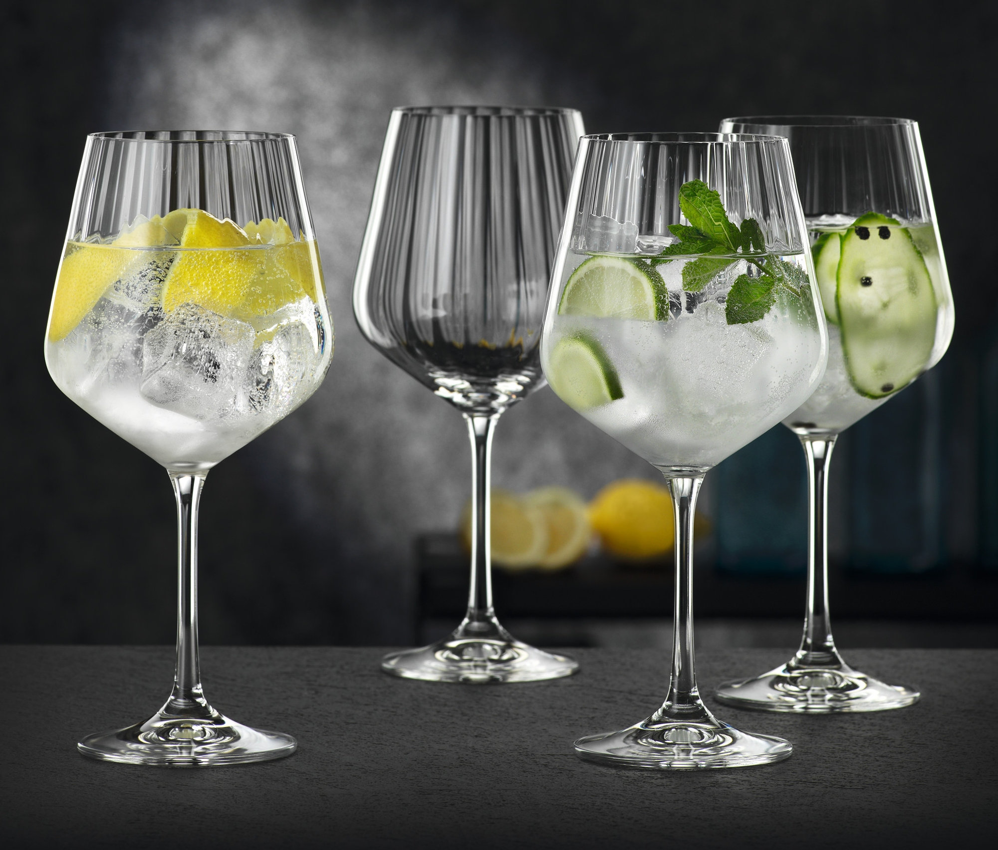 Vier Nachtmann Gläser Gin & Tonic »Celebration« gefüllt mit Eis, Zitrone, Limette, Gurke und Minze.