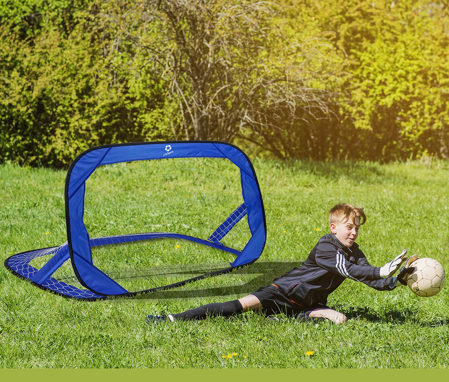 Ein Junge fängt einen Fußball vor einem blauen L.A. Sports Pop-Up-Tor auf einer Wiese.