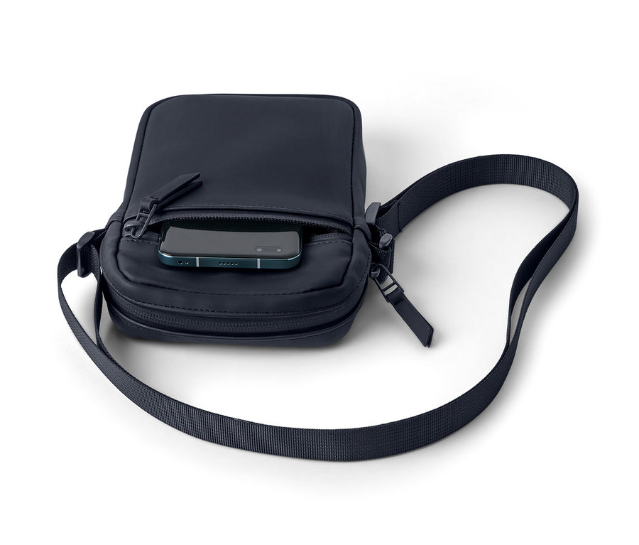 Eine marineblaue Regen-Umhängetasche mit einem Telefon in der Tasche.