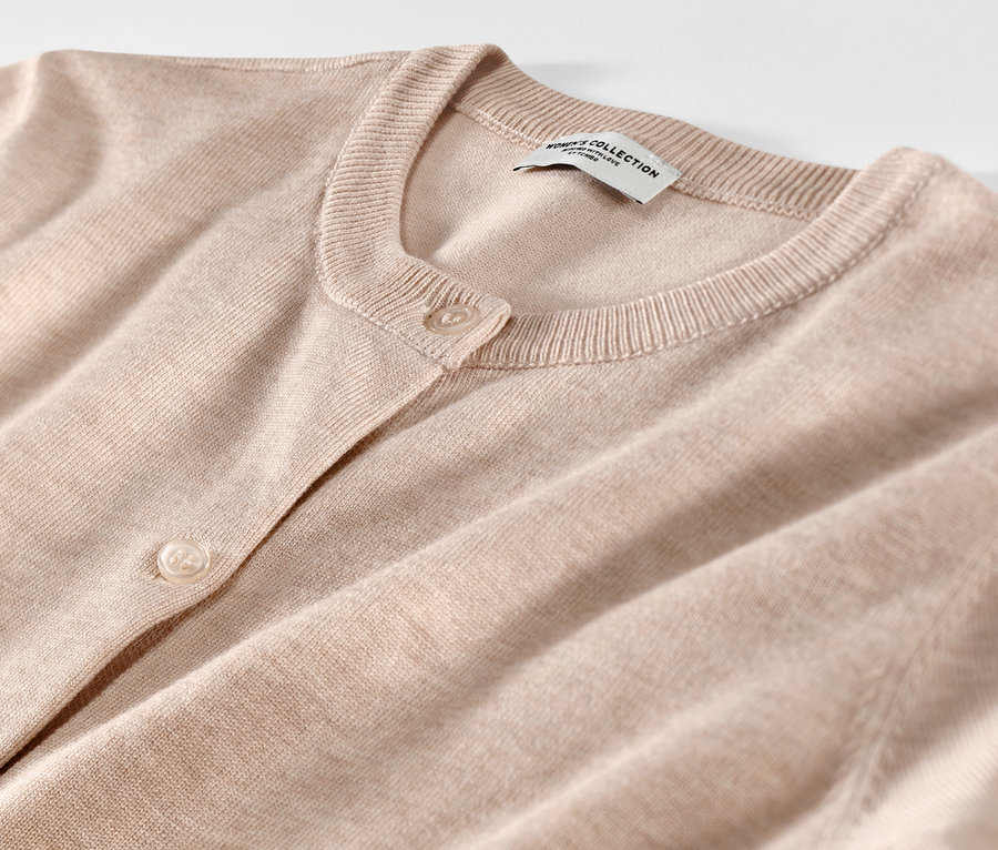 Detailaufnahme eines beigen Feinstrick-Cardigans.