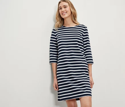 Blonde Frau trägt ein gestreiftes Sweatkleid.