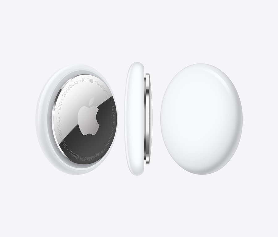 Drei Apple AirTags vor einem weißen Hintergrund. Einer wird von vorne, einer von der Seite und einer von hinten gezeigt.