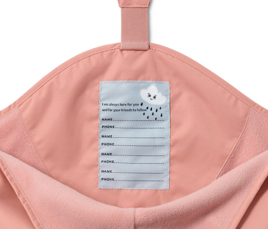Detail einer rosa Kinder-Thermo-Regenhose mit Innenetikett für Name und Telefonnummer.