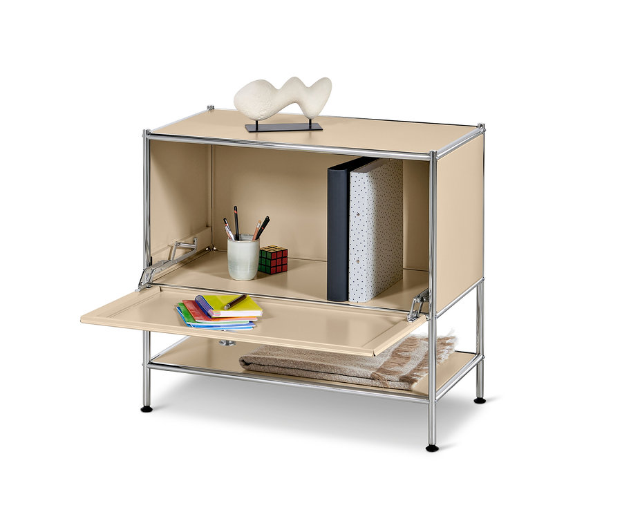 Beiges Sideboard Metall »CN3« mit Klappe. Auf der oberen Ablagefläche steht eine Deko-Skulptur, im geöffneten Schrank befinden sich ein Ordner, Stifte und ein Zauberwürfel. Auf der Klappe liegen Notizblöcke, auf der unteren Ablage eine Decke.