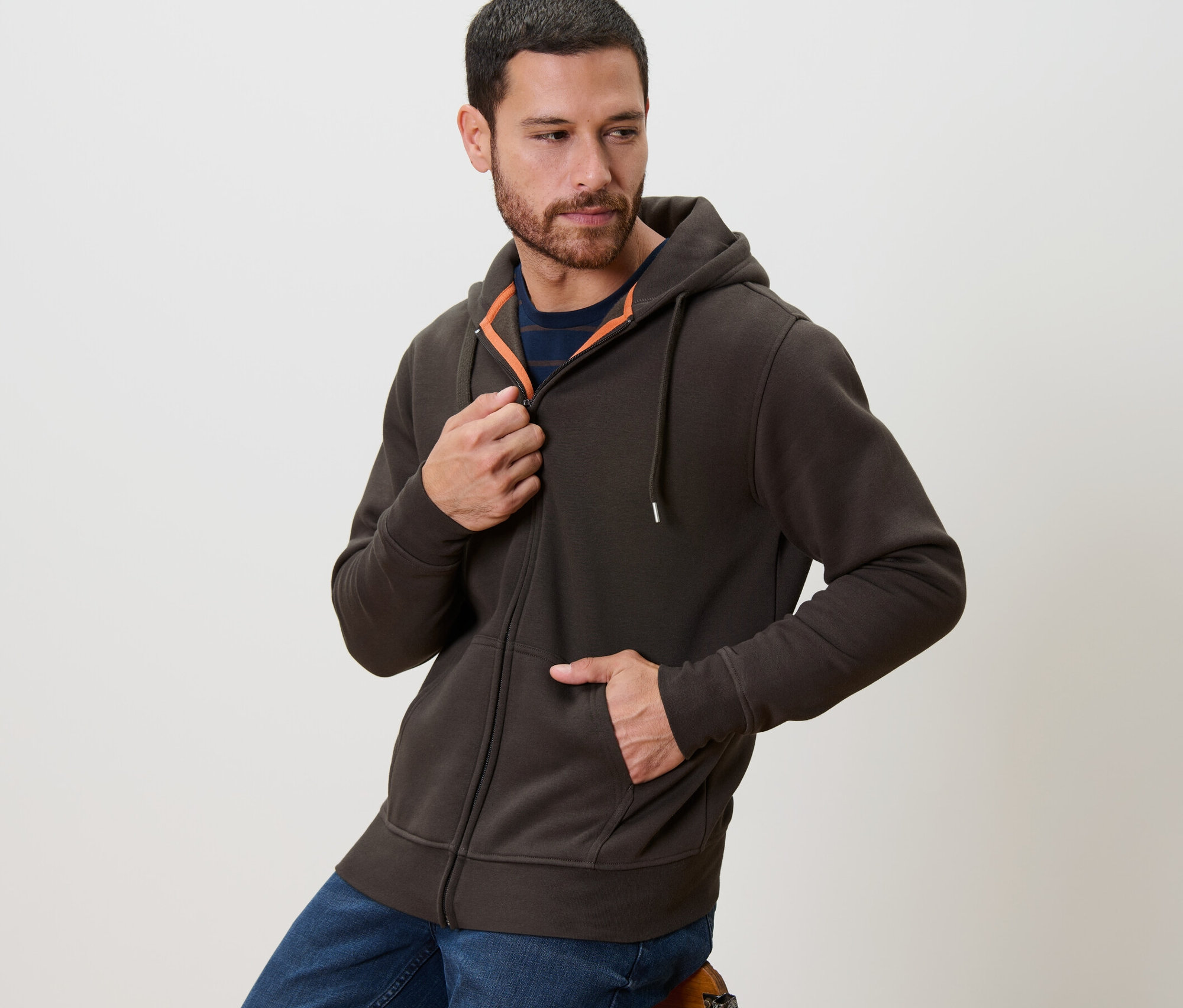 Mann schliesst braune Kapuzenjacke.