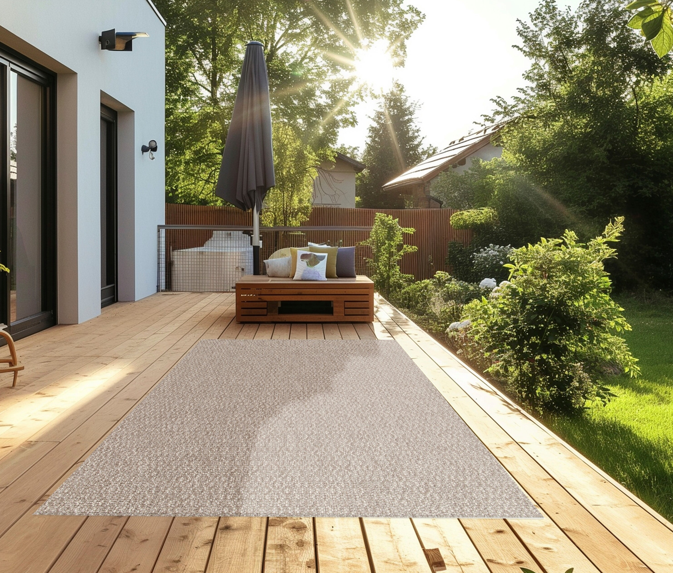 Auf einer Holzterrasse liegt ein beiger Teppich »Twine«.