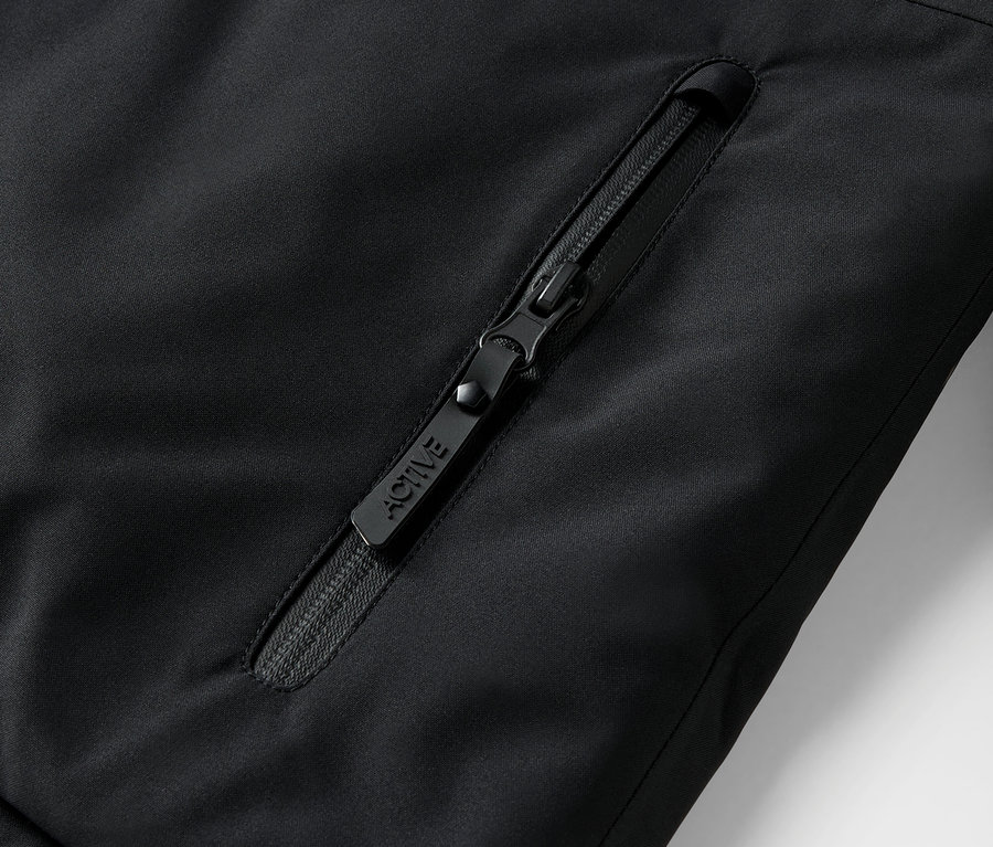 Detailaufnahme eines schwarzen Reißverschlusses an einer Jacke mit der Aufschrift ACTIVE.
