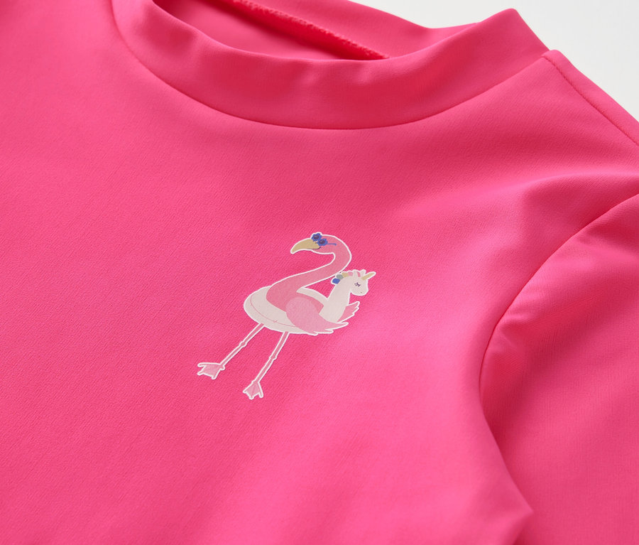 Detailaufnahme eines pinkfarbenen Kinder-Kombis mit UV-Schutzfaktor 80 und Flamingo-Aufdruck.