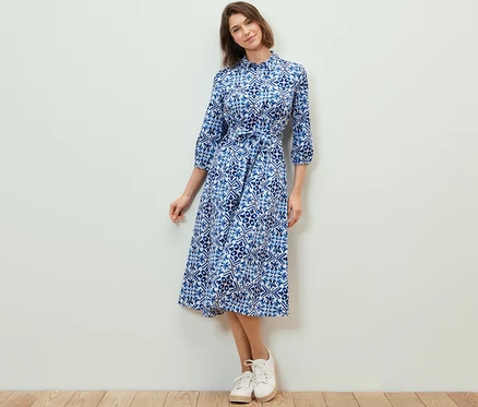 Frau posiert in einem bedruckten Midikleid.