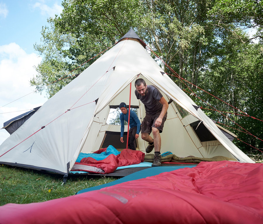 Zwei Männer vor Zelt, einer kommt heraus. Im Zeltinneren sind rote und blaue Isomatten zu sehen. Grand Canyon Doppel Isomatte »Hancock 7.5« ist sichtbar.