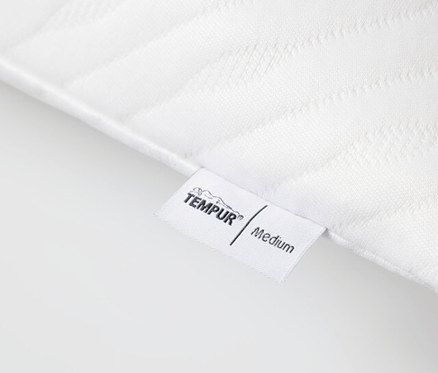 Detailansicht eines weißen TEMPUR PRIMA® Schlafkissen Medium mit Etikett.
