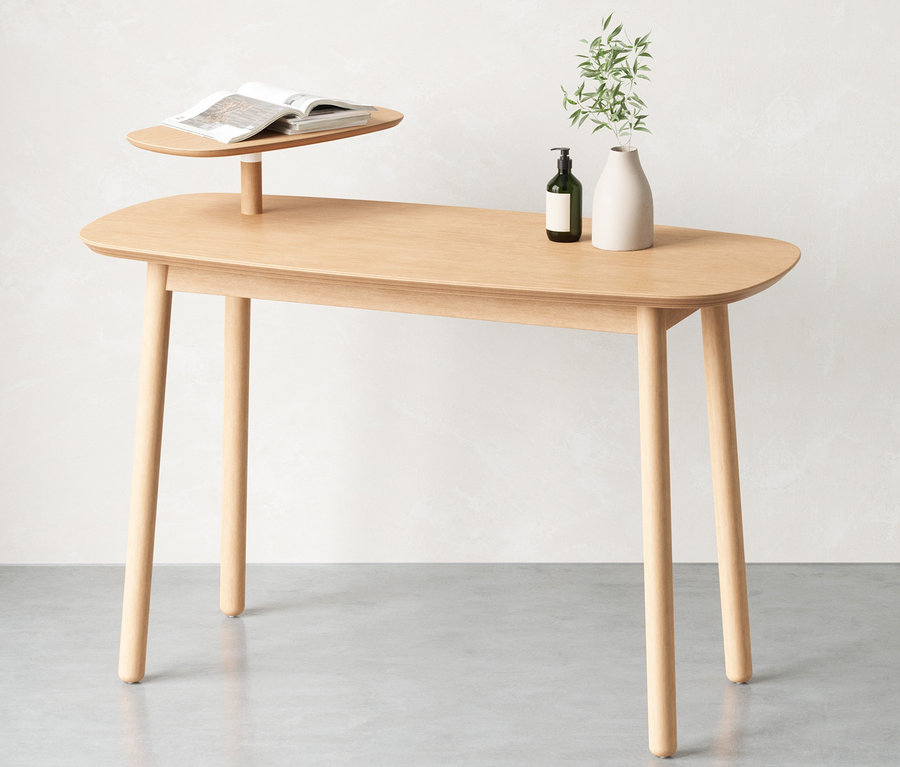 Ein hellbrauner Schreibtisch mit abgerundeten Ecken und einem Buch, einer Flasche und einer Vase darauf.
