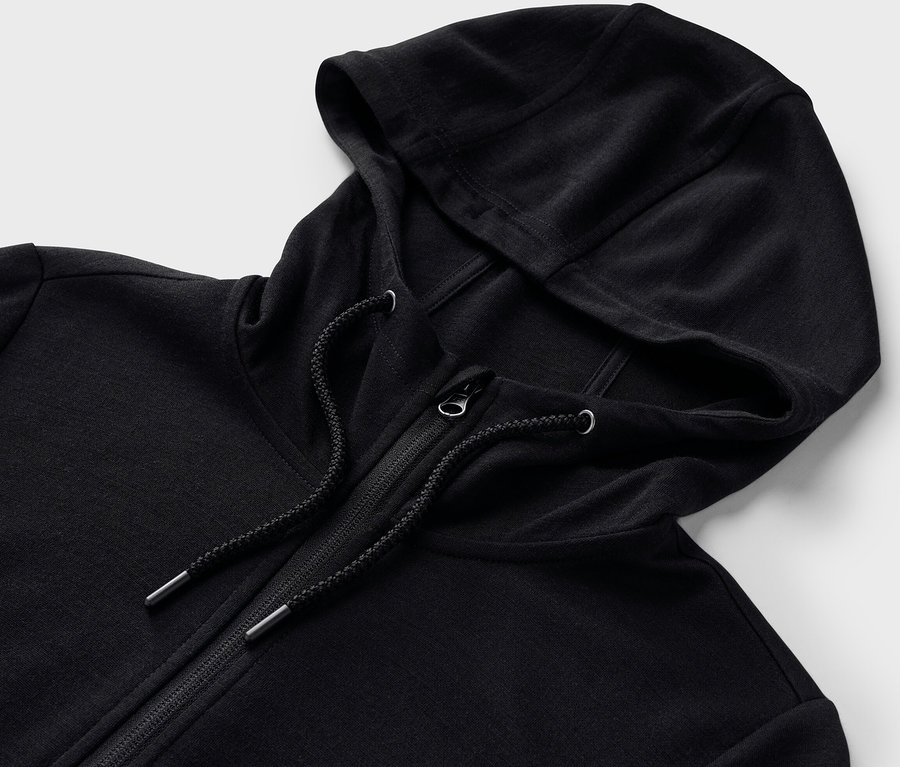 Detailaufnahme einer schwarzen Kapuzenjacke mit RWS-zertifizierter Wolle und Reißverschluss.