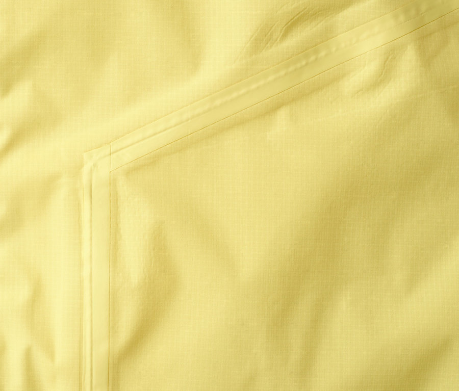 Detailansicht einer gelben Lightweight-Regenjacke »pack me«.