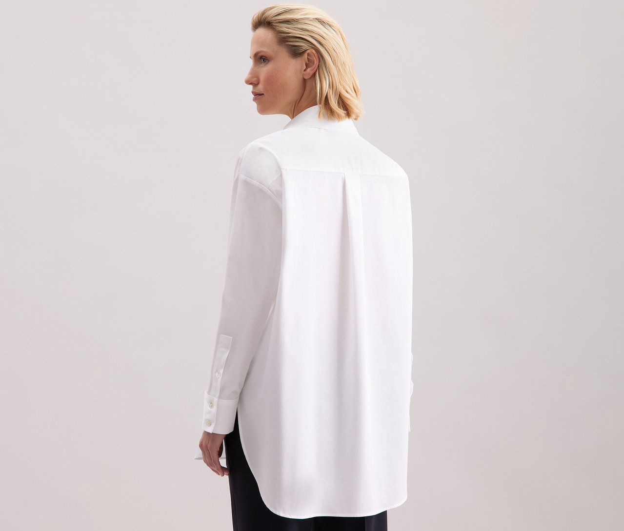 Frau von hinten, die eine weiße Seidensticker Oversize Longbluse trägt.