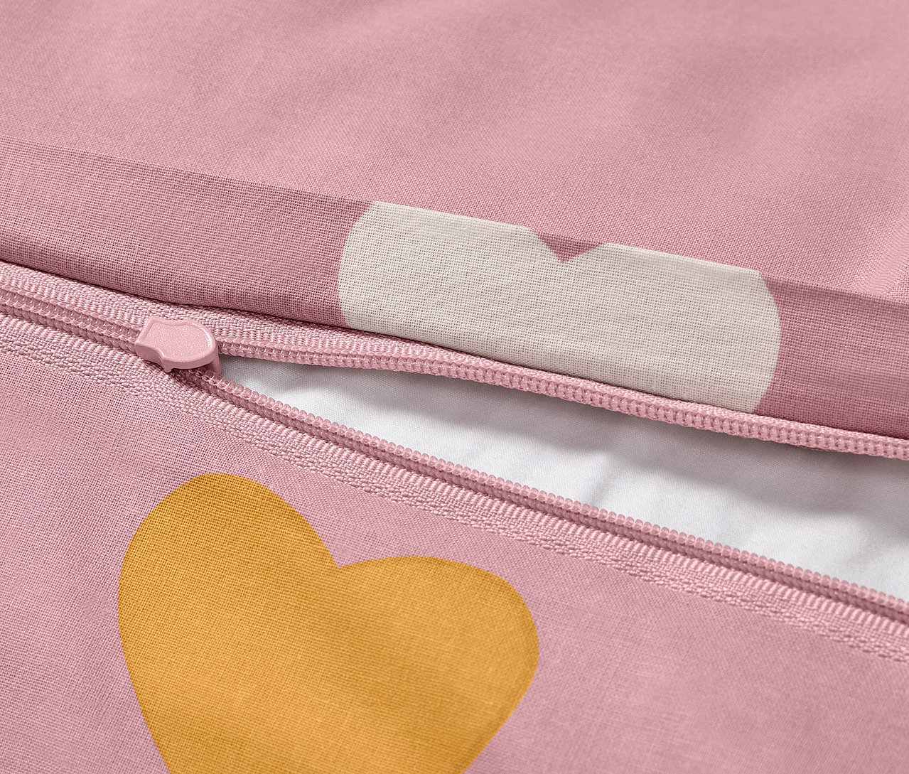 Detail einer Kinder-Renforcé-Bettwäsche in Normalgröße mit rosa Hintergrund und goldenem Herz.