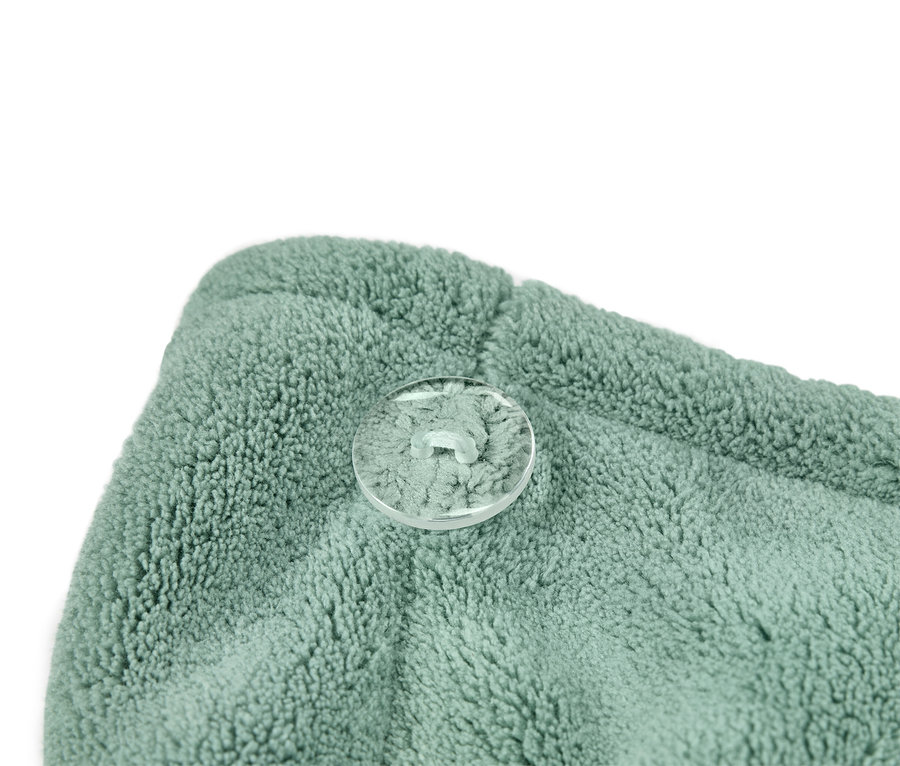 Nahaufnahme eines türkisgrünen Handtuch-Turbans mit transparentem Knopf.