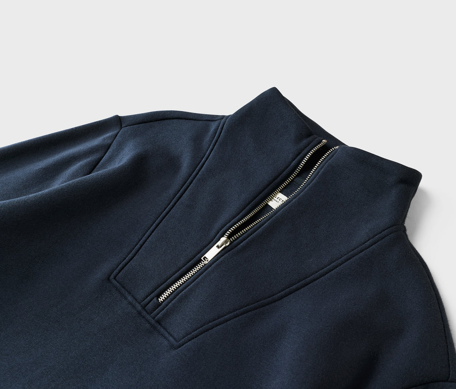 Detailaufnahme eines marineblauen Sweatshirts mit Reißverschluss am Kragen.