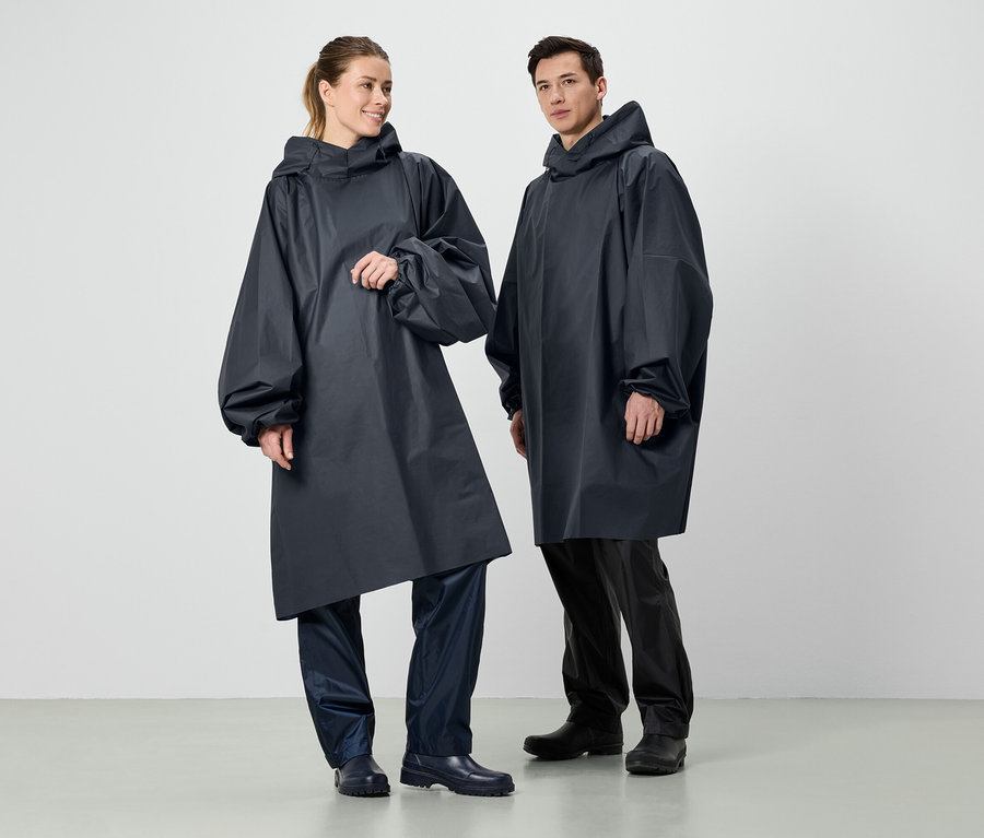 Zwei Personen stehen nebeneinander und tragen dunkelblaue Regenponchos mit Kapuze.