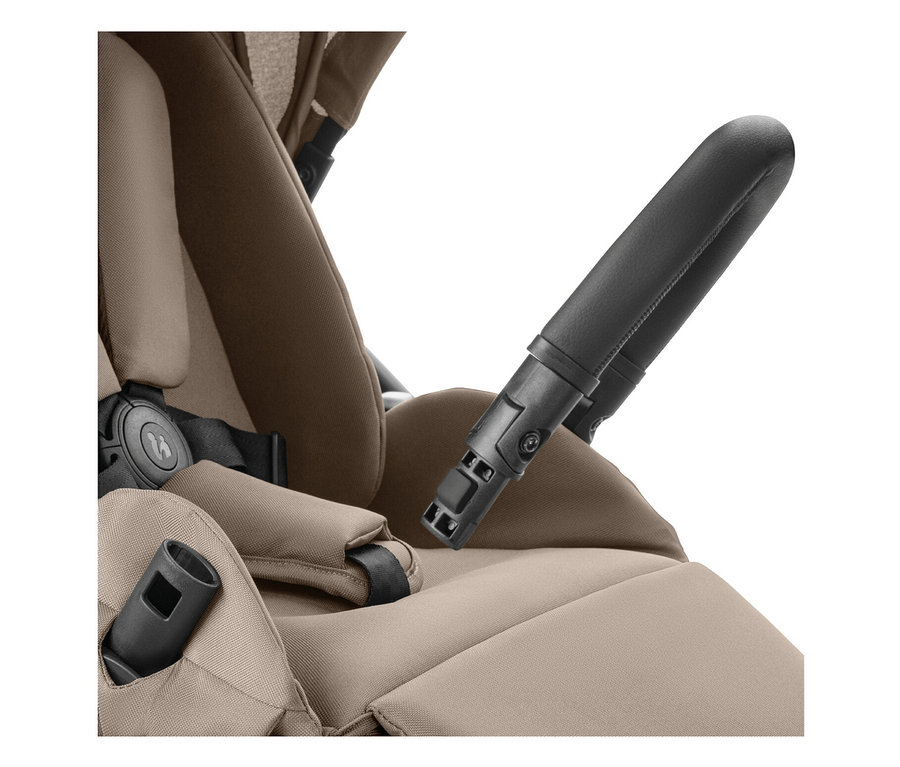 Nahaufnahme eines Kinderwagensitzes mit schwarzem Sicherheitsbügel und beigem Polster.