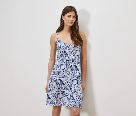 Frau trägt ein blau-weißes, ärmelloses Sommerkleid.