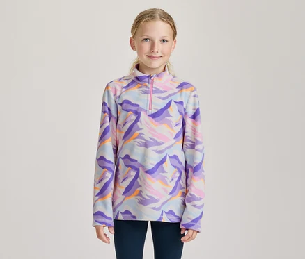 Lächelndes Mädchen in einem langärmeligen Fleece-Oberteil mit buntem, abstraktem Muster in Lila, Blau, Pink und Orange und einem pinken Halb-Reißverschluss.