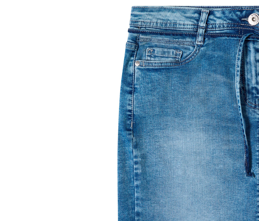Nahaufnahme eines blauen, verwaschenen CECIL Jeansrocks, der den Bund mit Gürtelschlaufen, eine kleine Münztasche, eine größere geschwungene Tasche mit silbernem Niet und ein Denim-Band auf der rechten Seite zeigt.