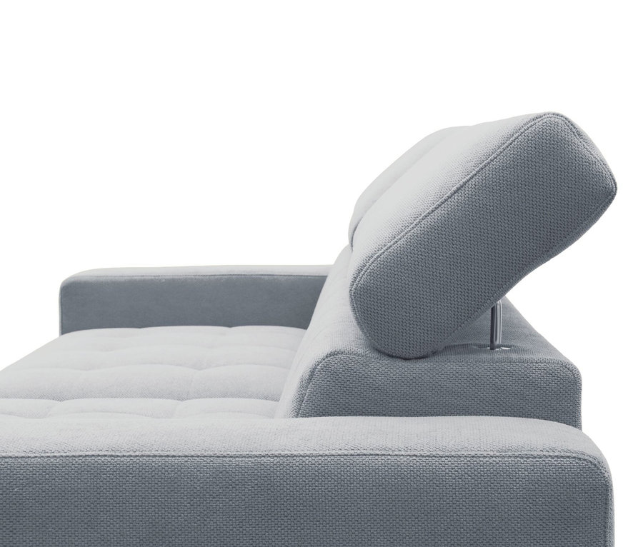 Nahaufnahme eines hellgrauen Stoffsofas mit gesteppter Sitzfläche und einer nach oben verstellten Kopfstütze vor weißem Hintergrund.