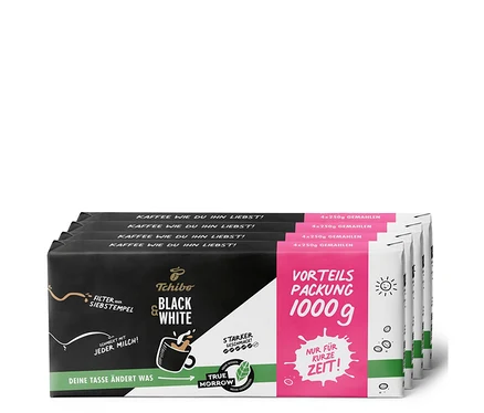 Vier Packungen Tchibo Black & White gemahlener Kaffee, jede Packung enthält 1 kg Kaffee.