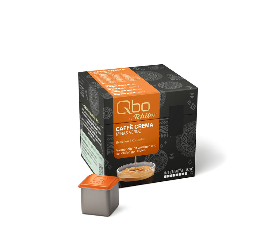 Dunkelgraue Qbo Caffè MINAS VERDE Kapselpackung mit orangefarbener Banderole und eine einzelne graue Kapsel mit orangefarbenem Deckel davor.