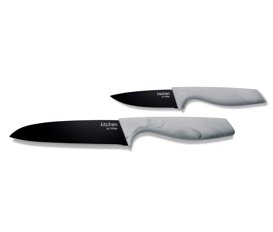 Zwei Küchenmesser aus dem Küchenmesser-Set mit schwarzer Klinge und grauem Griff liegen auf einem weißen Hintergrund.