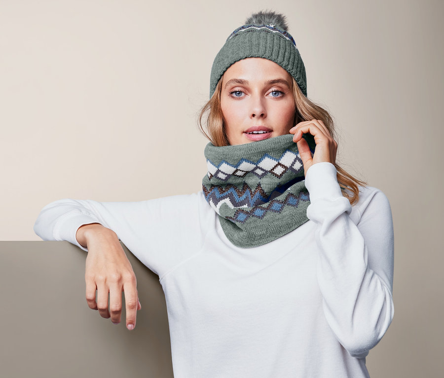 Frau trägt einen Strick-Loopschal und eine Strickmütze.