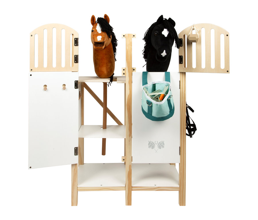 Der small foot Hobby-Horse-Pferdestall mit zwei Steckenpferden, einem blauen Sack mit Karotten und einer offenen Tür.