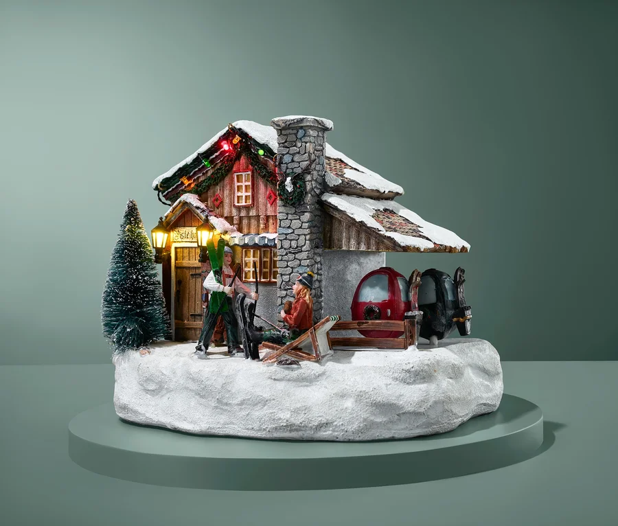 Beleuchtetes Luville – Ski-Hotel Modell mit Skifahrerfiguren und verschneiter Landschaft.