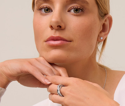 Blonde Frau mit 925 Silber Ohrstecker Solitär, 925 Silber Kette Solitär und Ring Loops mit Kristallen.