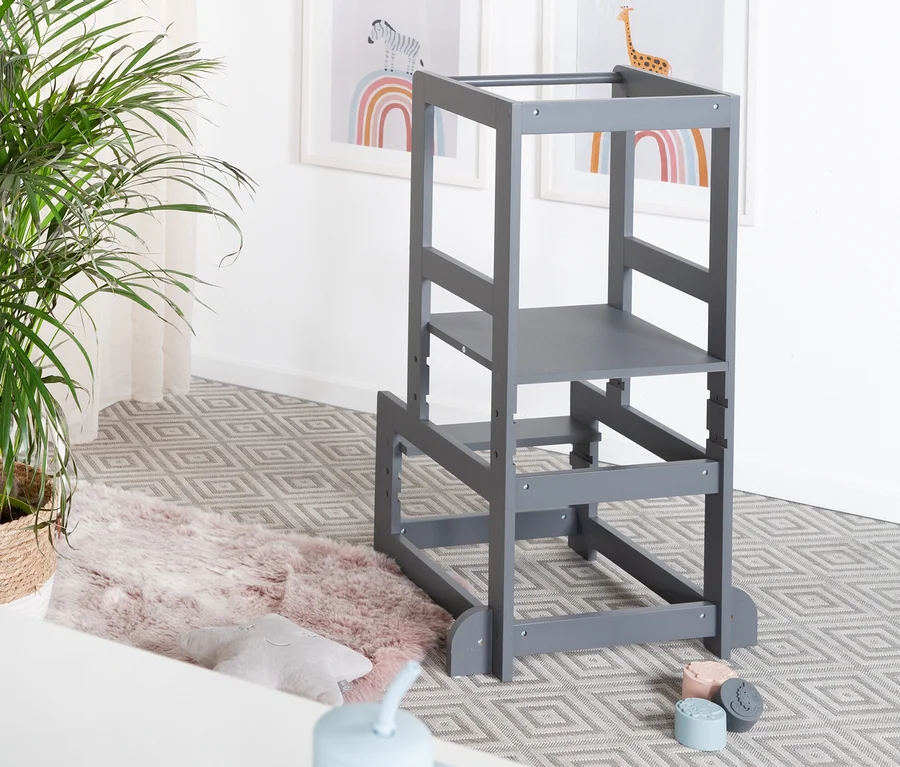 Ein anthrazitfarbener Roba Lernturm steht in einem Kinderzimmer neben einer Topfpflanze.