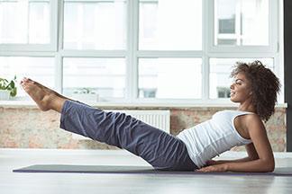 Eine frau macht in ihrer grauen Sporthose Sport.